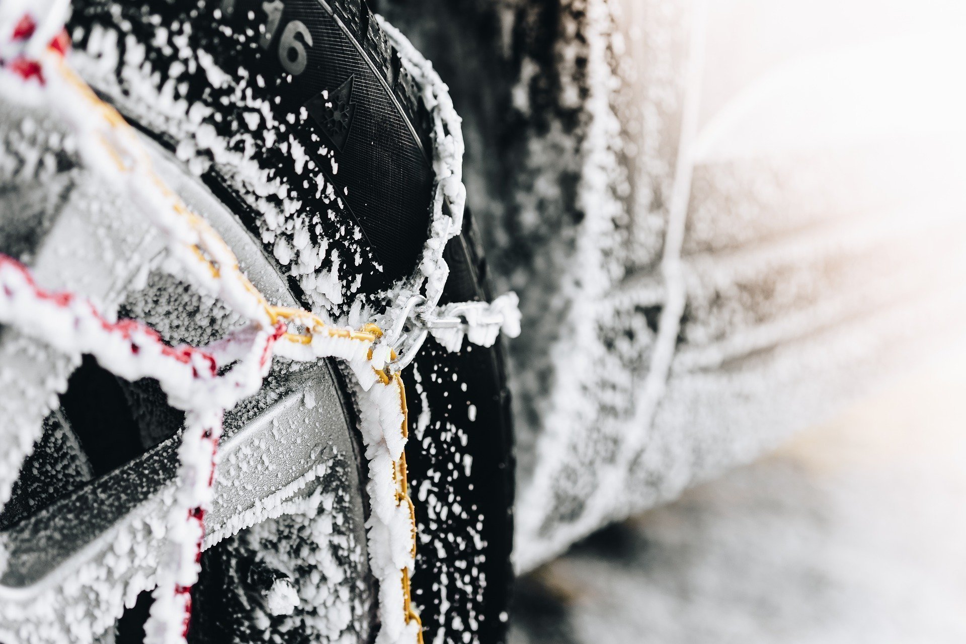 Schneeketten und Winterreifen auf verschneiter Fahrbahn